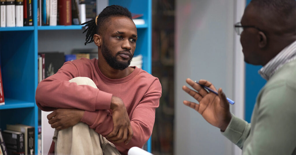 Portrait of black man listening to mental health therapist